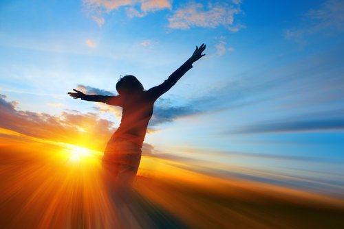 donna-braccia-aperte-con-tramonto